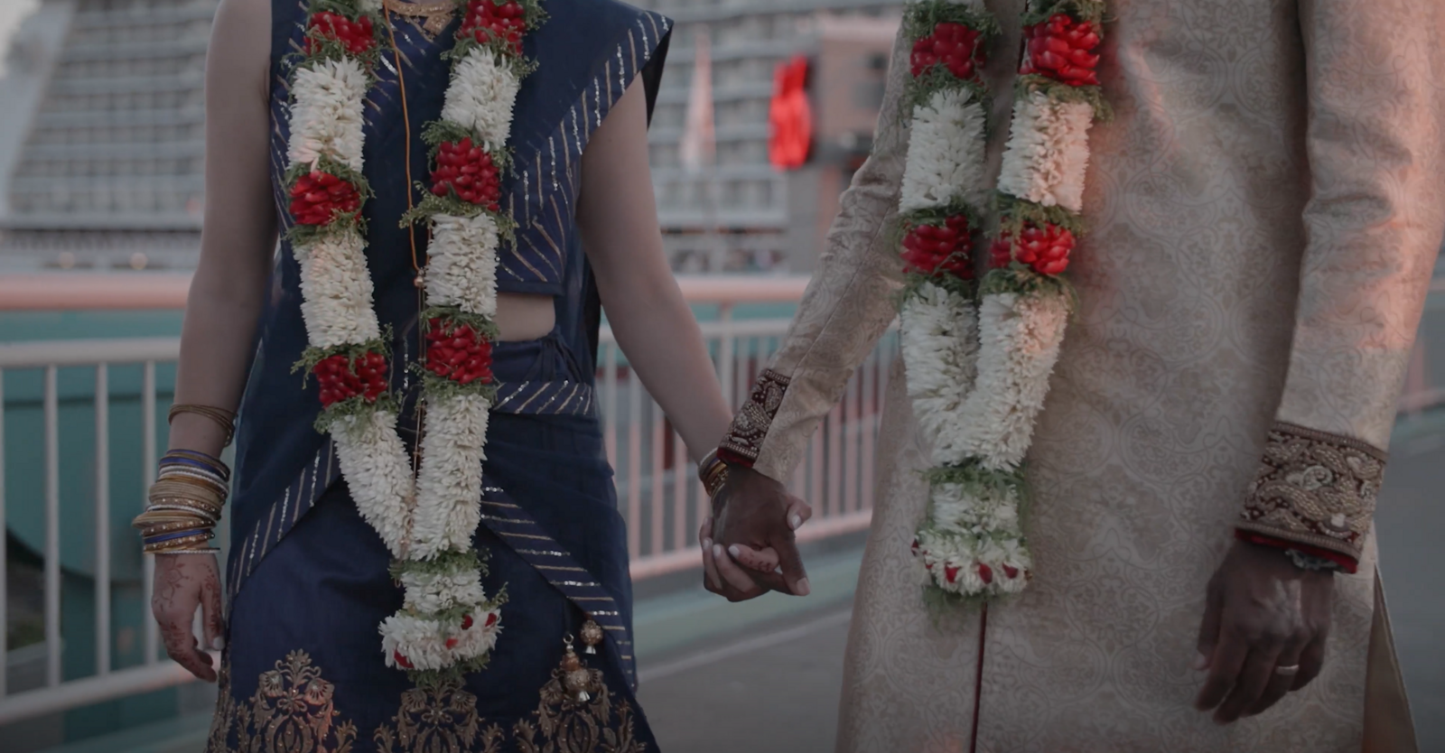Megan + Anand holding hands in their traditional Indian wedding attire